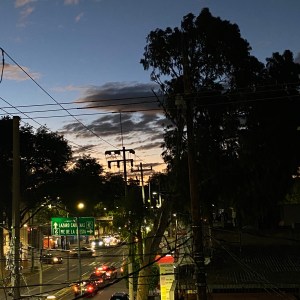 UNA MUJER HABLANDO AL CELULAR Y EN LA VENTANA EL REFLEJO DE UNAS NUBES GIGANTESCAS